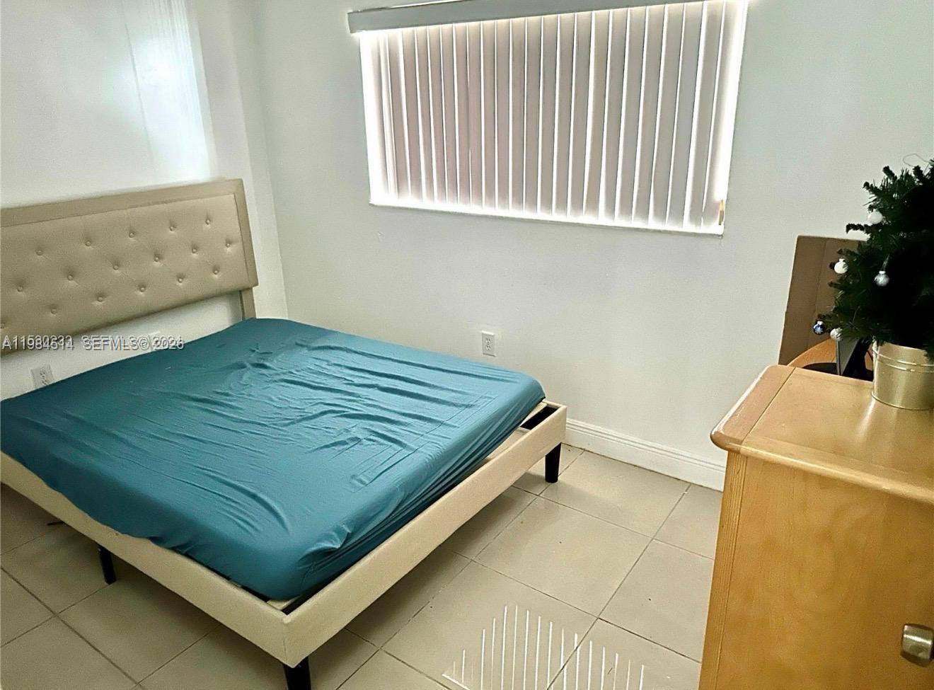 8650 Southwest 133rd Avenue Road, Unit 314 Miami, FL 33183 - Photo 5 of 13 a bed sitting in a bedroom next to a window