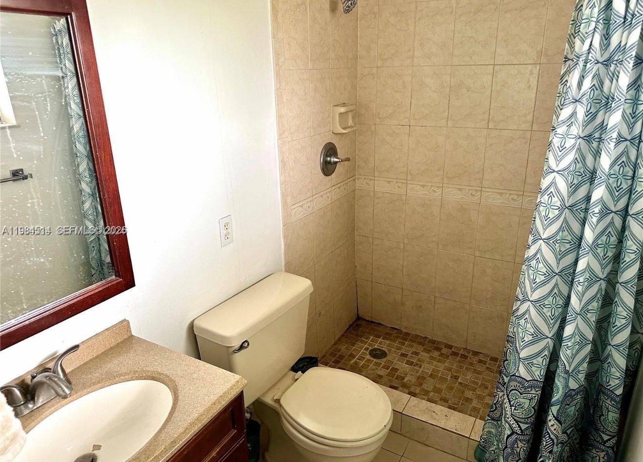 8650 Southwest 133rd Avenue Road, Unit 314 Miami, FL 33183 - Photo 6 of 13 a white toilet sitting next to a bathroom sink and a shower