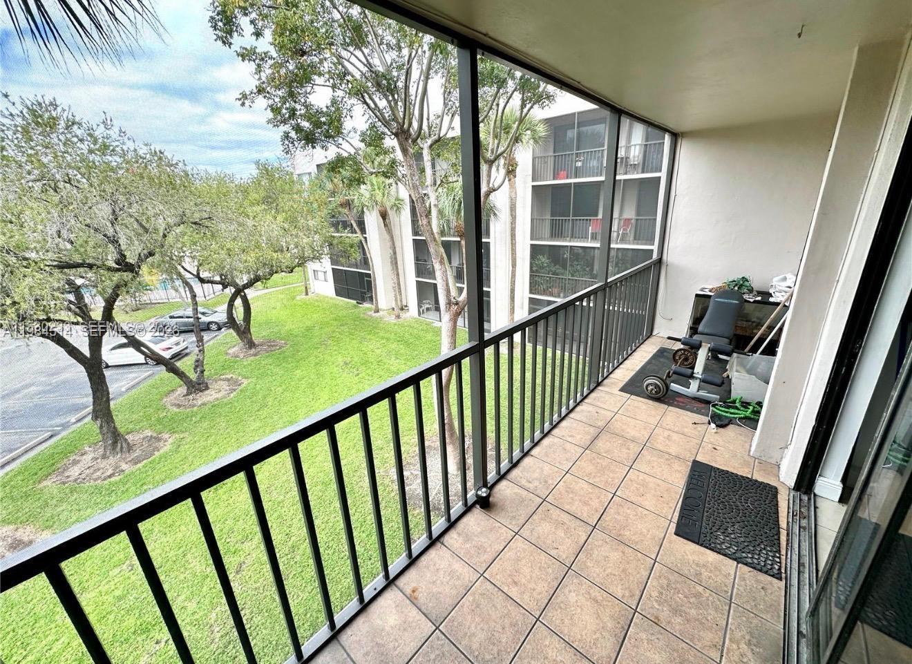 8650 Southwest 133rd Avenue Road, Unit 314 Miami, FL 33183 - Photo 7 of 13 a view of balcony with wooden floor and fence