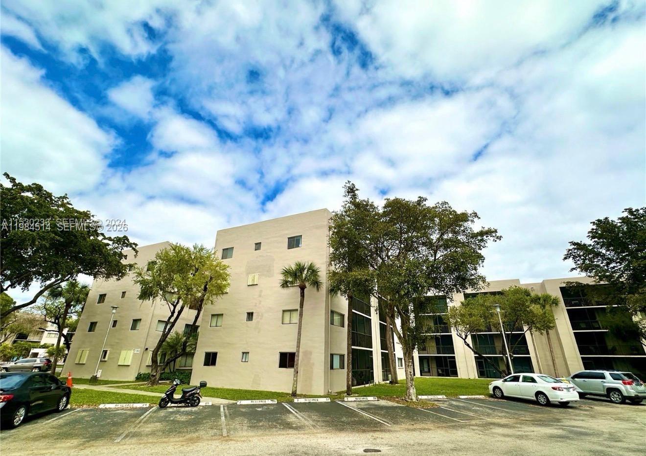 8650 Southwest 133rd Avenue Road, Unit 314 Miami, FL 33183 - Photo 9 of 13 a view of a building with floor to ceiling windows and trees