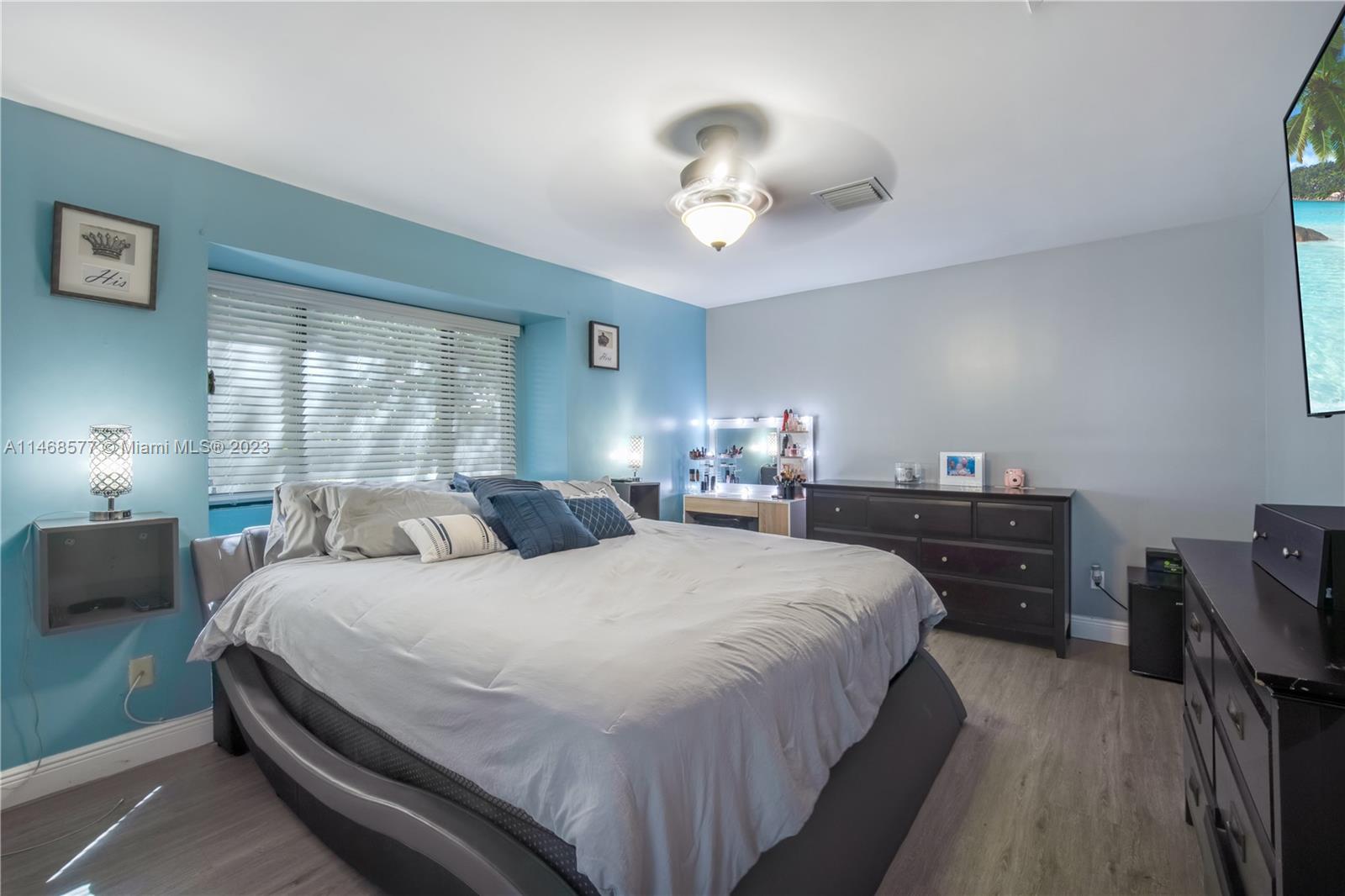 5232 Gate Lake Road, Unit 5232 Tamarac, FL 33319 - Photo 17 of 37 a bedroom with bed and a chandelier