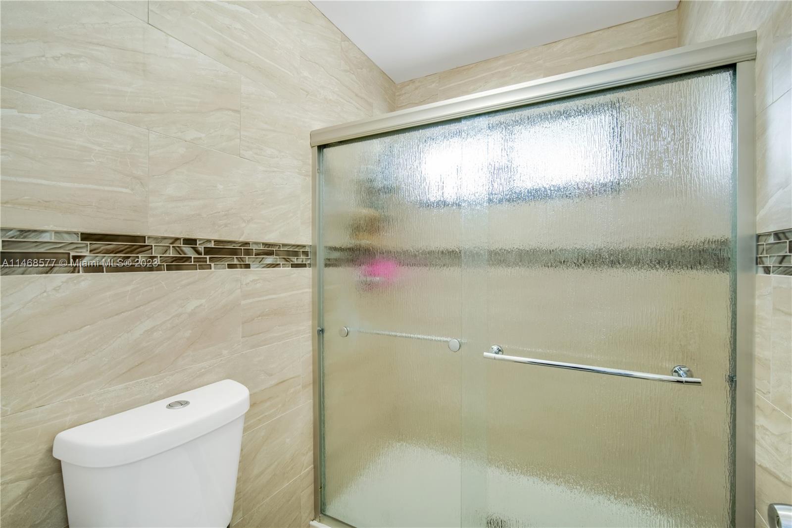 5232 Gate Lake Road, Unit 5232 Tamarac, FL 33319 - Photo 19 of 37 a bathroom with a toilet and a shower