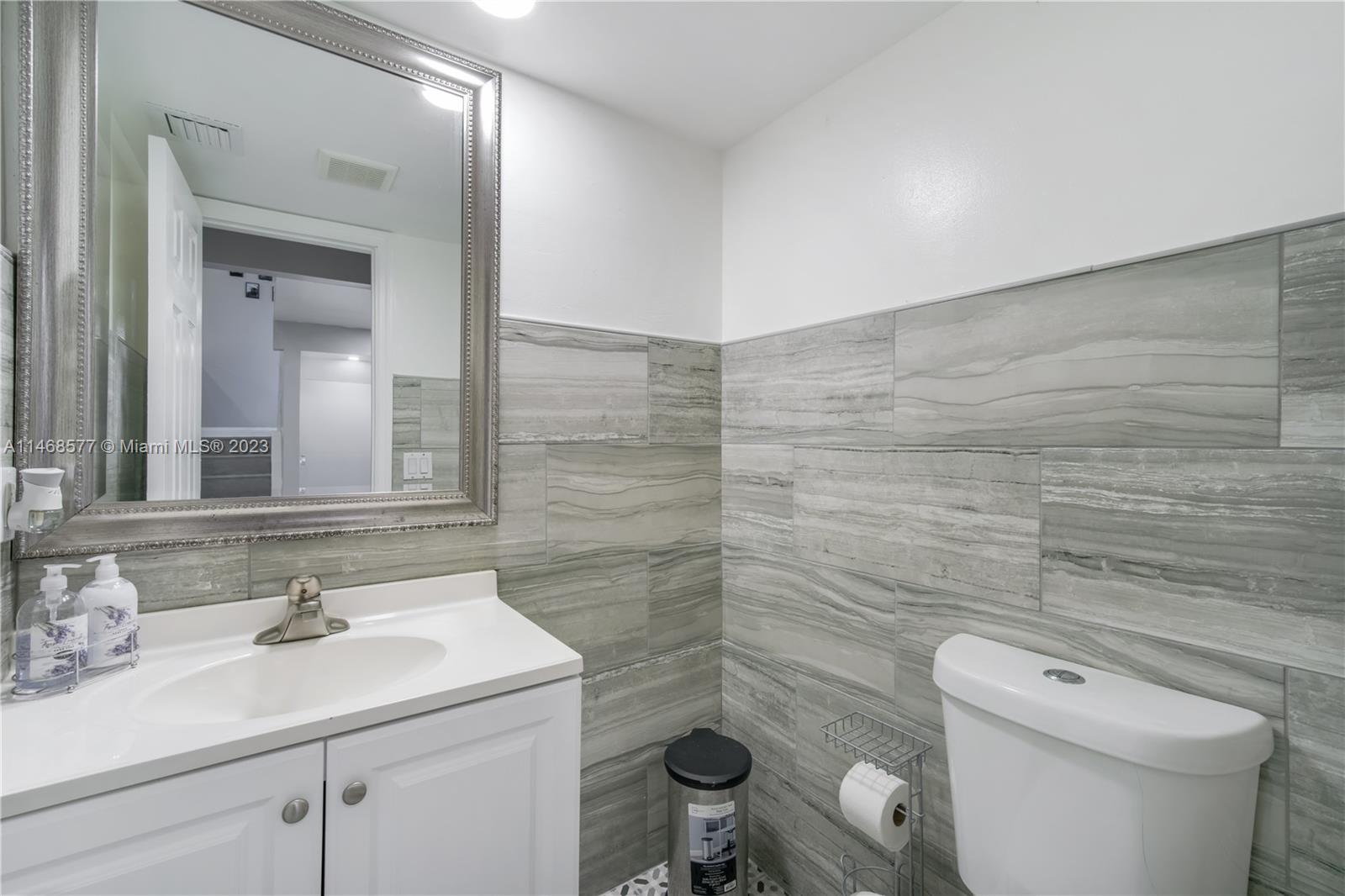 5232 Gate Lake Road, Unit 5232 Tamarac, FL 33319 - Photo 9 of 37 a bathroom with a sink a toilet and a mirror