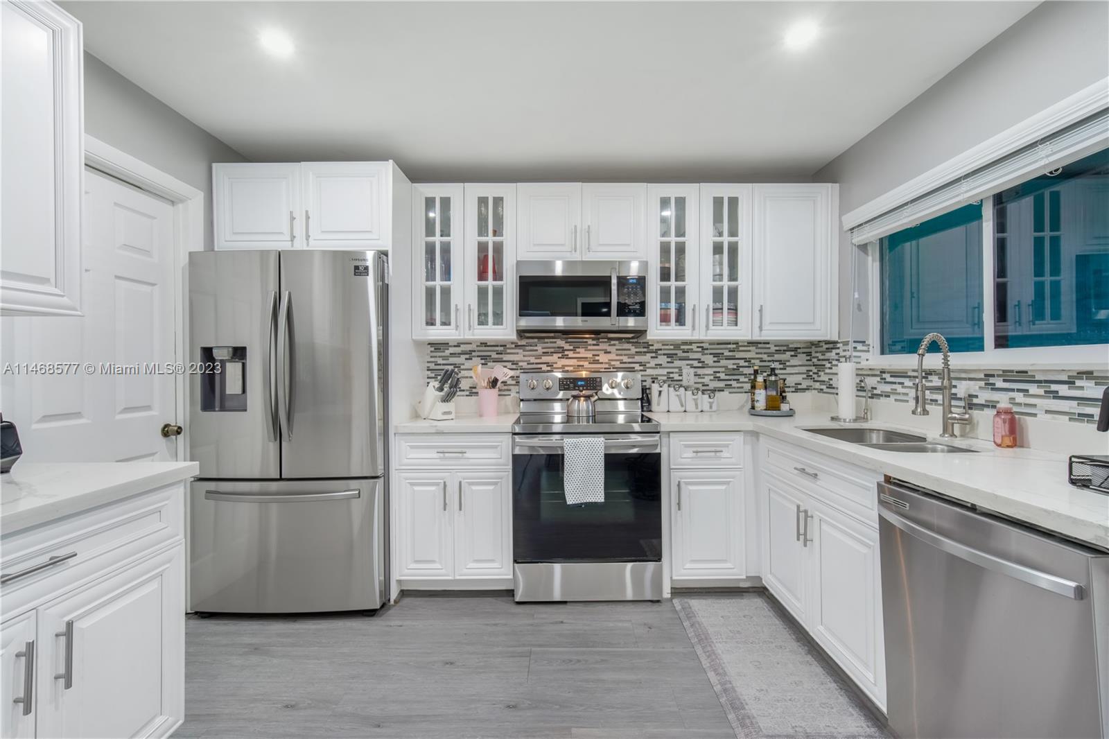 5232 Gate Lake Road, Unit 5232 Tamarac, FL 33319 - Photo 10 of 37 a kitchen with stainless steel appliances a refrigerator sink and microwave