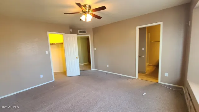 an empty room with a ceiling fan and a window