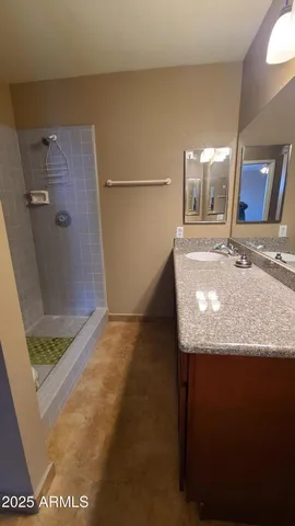 a bathroom with a granite countertop sink and a mirror