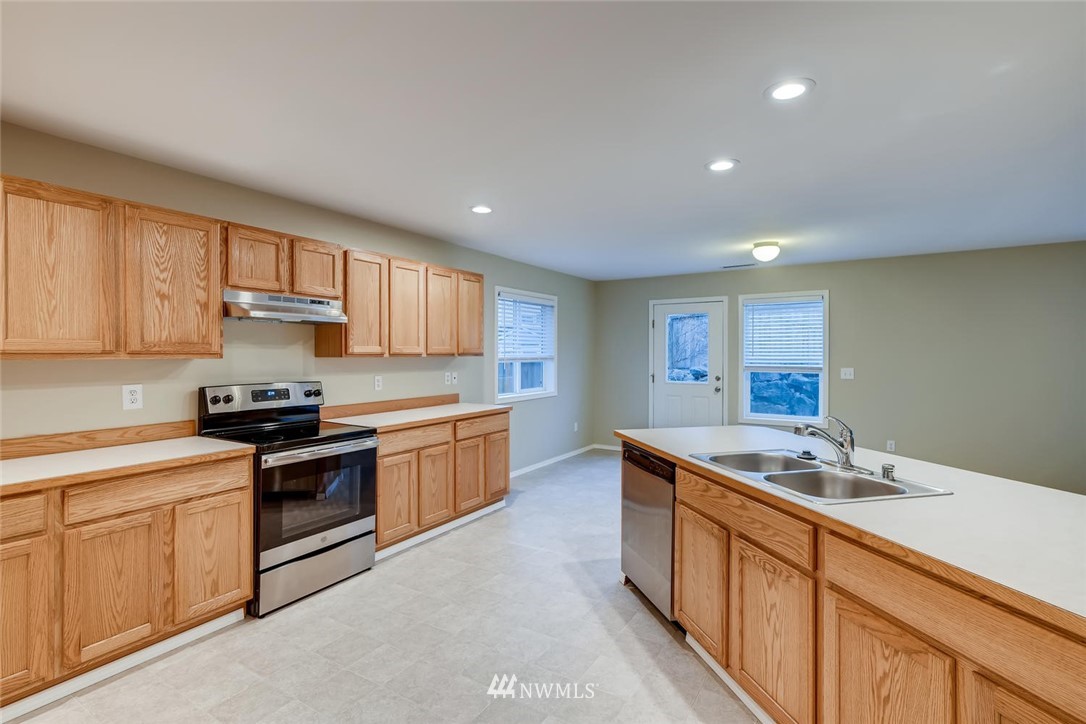309 Index Place Southeast Renton, WA 98056 - Photo 10 of 28 a kitchen with stainless steel appliances granite countertop a sink stove and cabinets