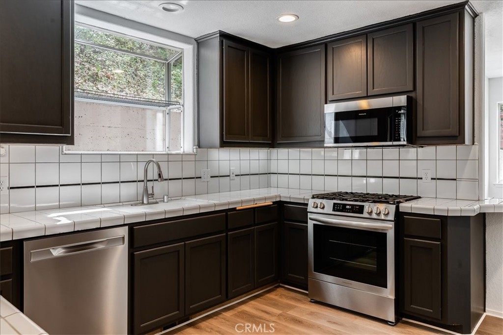 6281 York Mountain Road Templeton, CA 93465 - Photo 10 of 31 a kitchen with stainless steel appliances a stove sink and cabinets