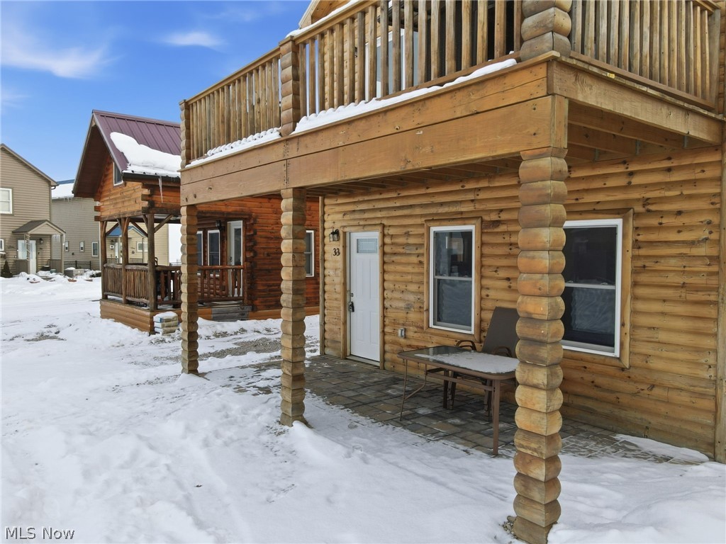 5919 Lake Road West, Unit 32 Ashtabula, OH 44004 - Photo 2 of 23 Snow covered property entrance with a patio, a wooden deck, log exterior, and a metal roof