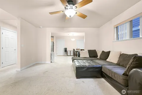 a living room with furniture and a ceiling fan