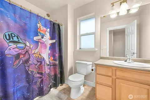 a bathroom with a granite countertop toilet sink and mirror