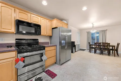 a kitchen with stainless steel appliances granite countertop a stove refrigerator and microwave