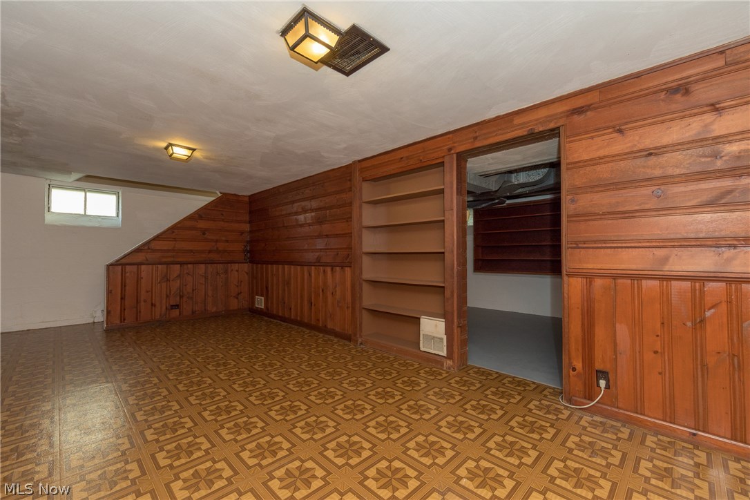 1235 Winston Road Cleveland, OH 44121 - Photo 25 of 30 The full length, lower level, Recreation Room with convenient built-in library display shelves