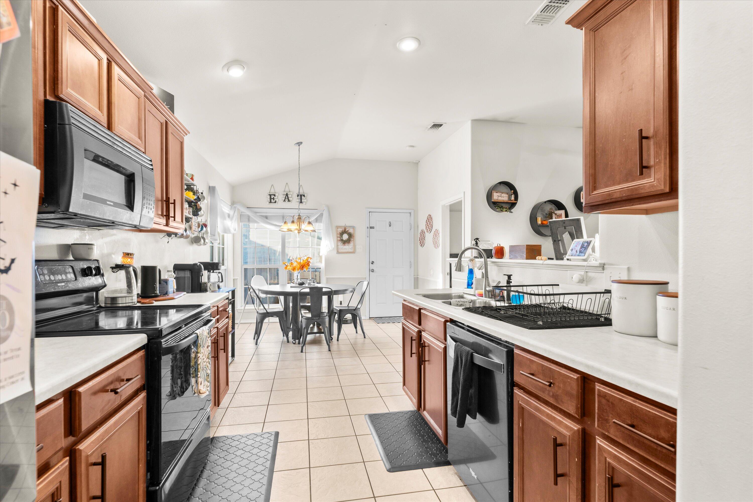 6513 85th Street Lubbock, TX 79424 - Photo 11 of 22 a kitchen with stainless steel appliances granite countertop a stove a sink and a refrigerator