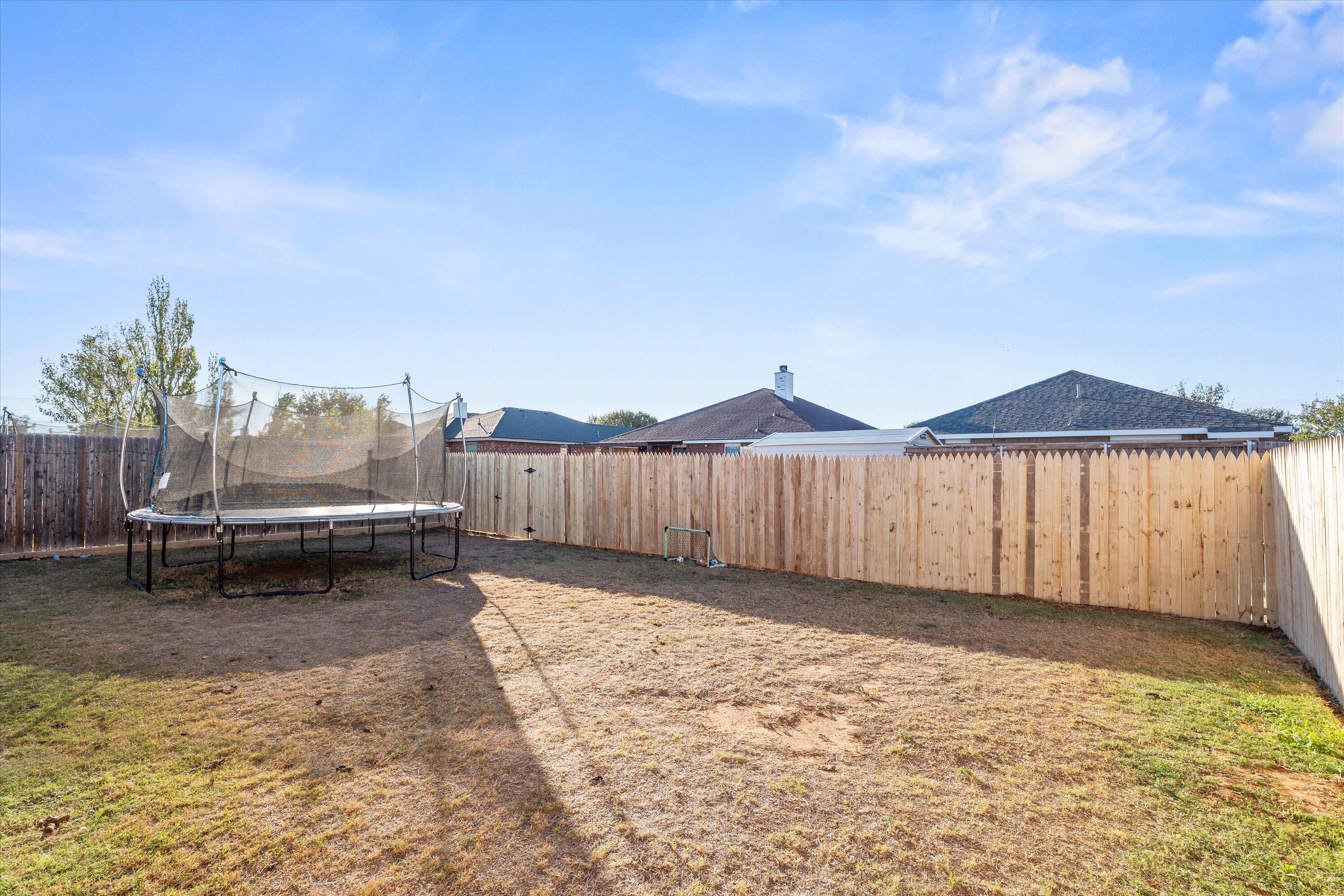 6513 85th Street Lubbock, TX 79424 - Photo 21 of 22 a view of a backyard with a small pool and wooden fence