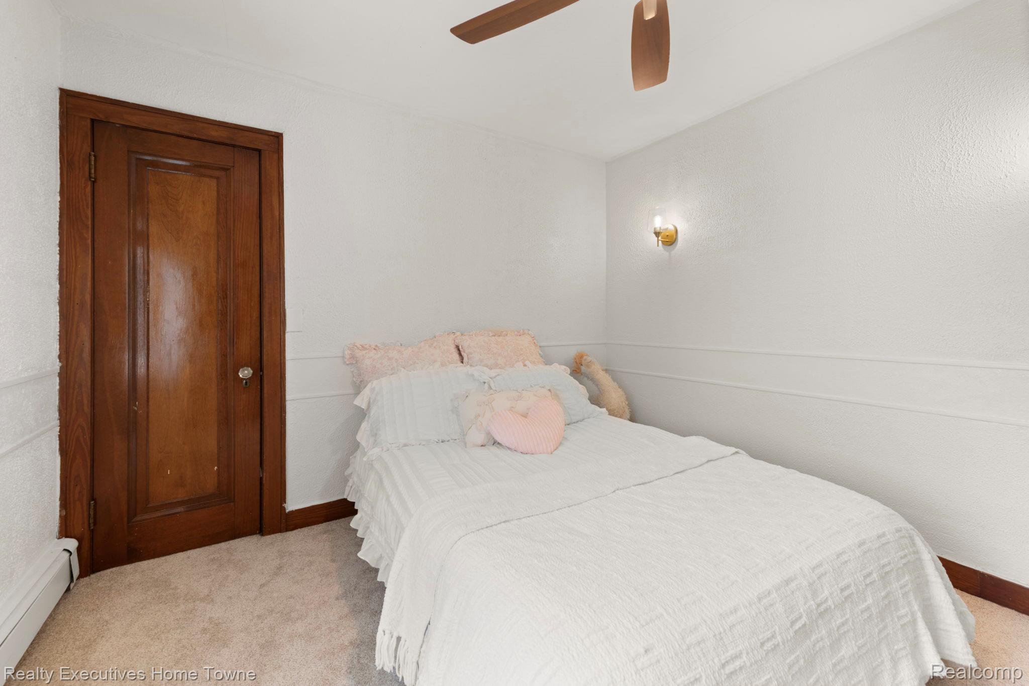 8308 Lakeshore Road Fort Gratiot, MI 48059 - Photo 55 of 79 White interior walls with chair rail molding and a brass wall sconce