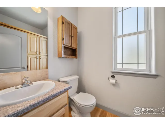 a bathroom with a granite countertop sink toilet and mirror