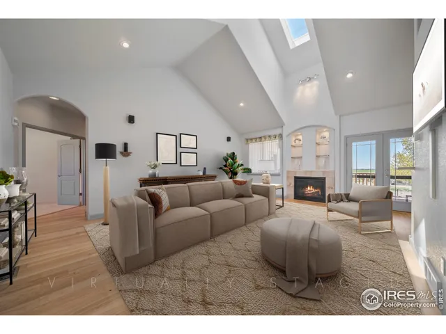 a living room with furniture a fireplace and a dining table with wooden floor