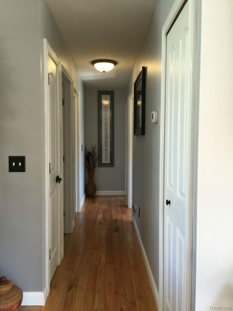5926 Bentley Lake Road Howell, MI 48843 - Photo 9 of 22 Hall to bedrooms, all hardwood with new 6 panel doors and hardware
