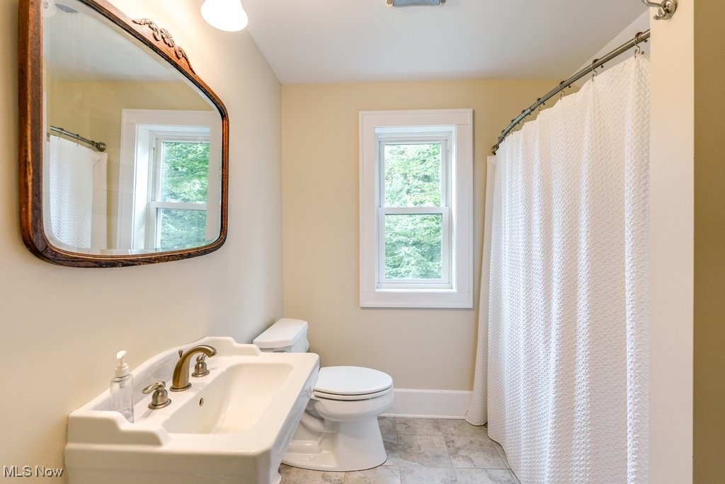 2980 Luli Road Mogadore, OH 44260 - Photo 44 of 50 Bathroom featuring toilet, a shower with shower curtain, sink, and tile patterned floors