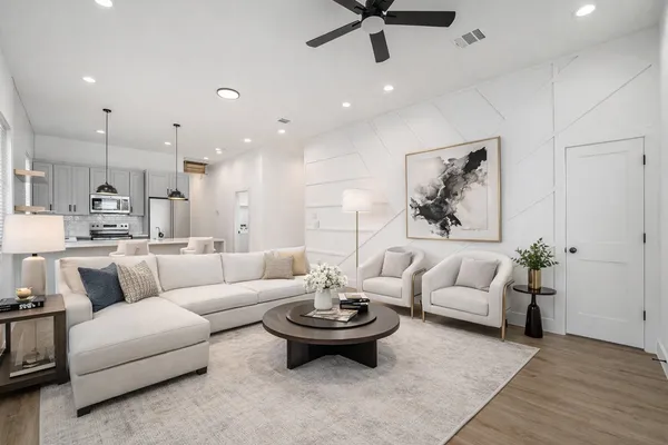 a living room with furniture and a view of kitchen