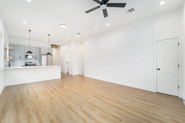 a view of an empty room and kitchen view
