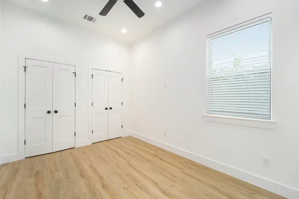 an empty room with a window and ceiling fan