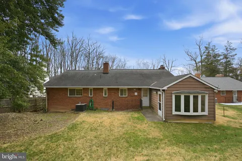 a front view of a house with a garden and tree