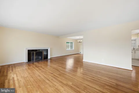 a view of a livingroom with wooden floor and a fireplace