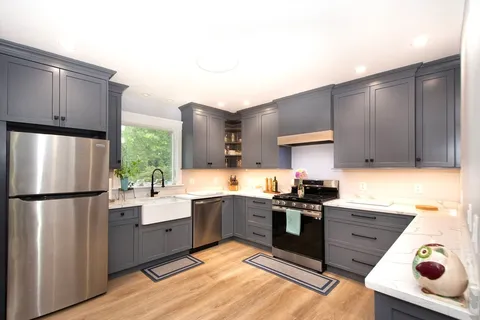 a kitchen with stainless steel appliances granite countertop a refrigerator sink and stove