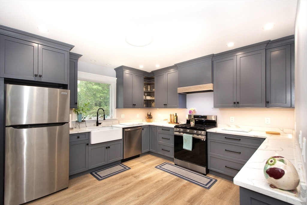 a kitchen with stainless steel appliances granite countertop a refrigerator sink and stove