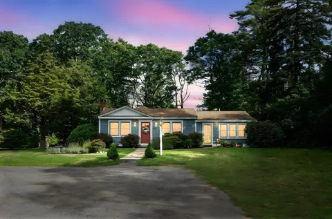 a front view of a house with a yard and green space