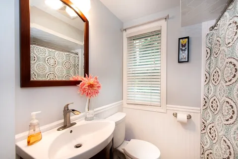 a bathroom with a toilet sink and mirror