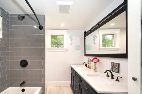 a bathroom with a sink mirror and tub