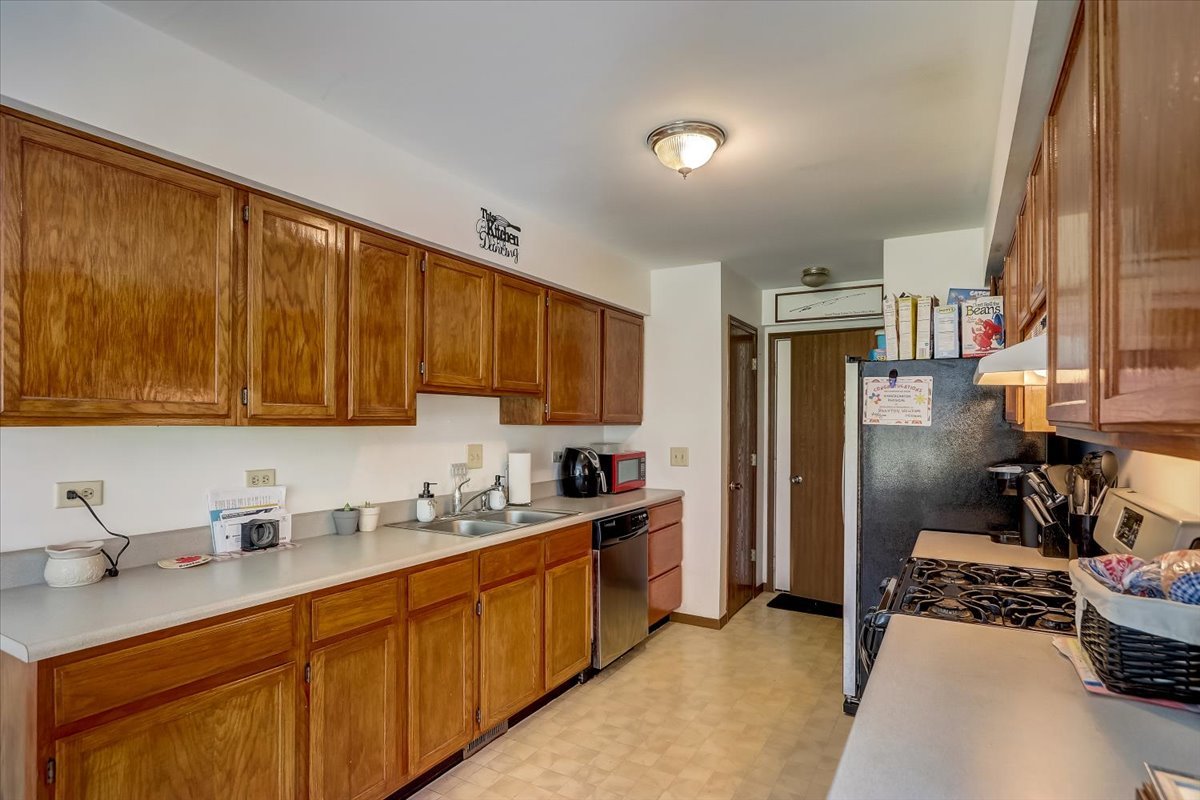 323 Village Creek Drive Lake In The Hills, IL 60156 - Photo 7 of 28 a kitchen with stainless steel appliances granite countertop a sink stove and refrigerator