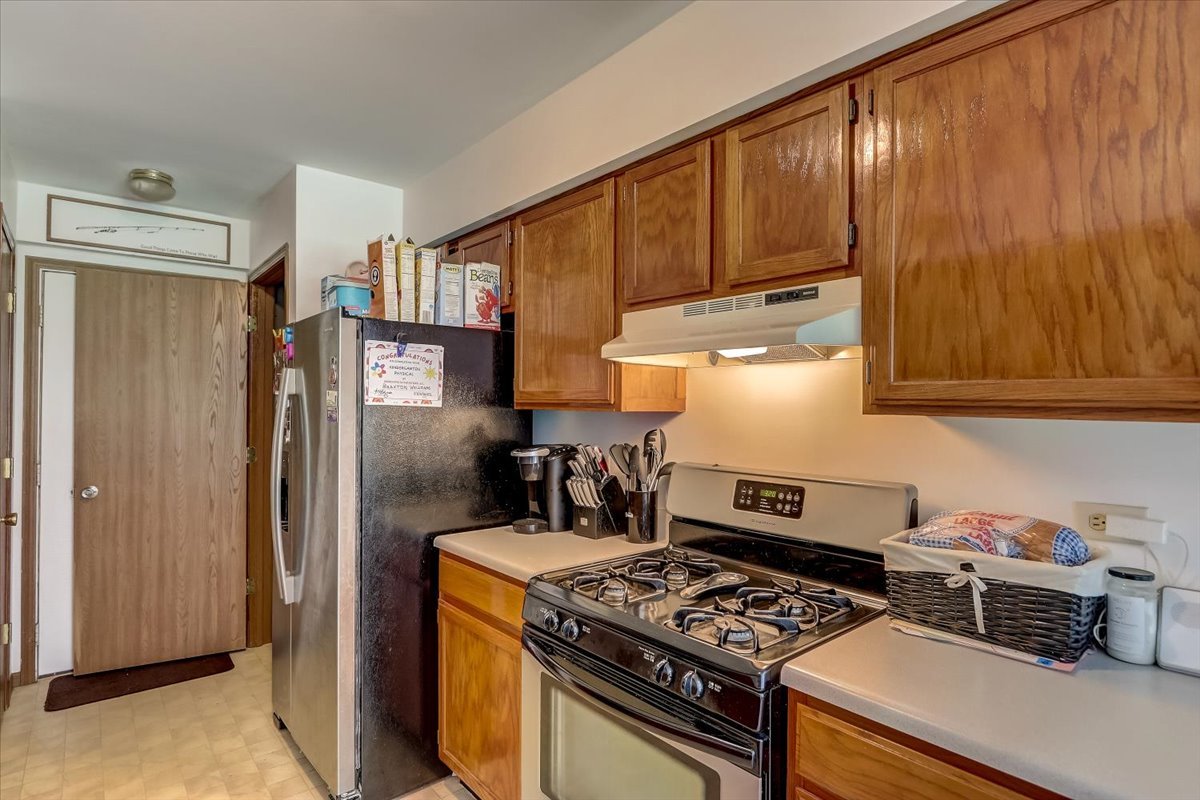 323 Village Creek Drive Lake In The Hills, IL 60156 - Photo 9 of 28 a kitchen with stainless steel appliances granite countertop a stove and a refrigerator
