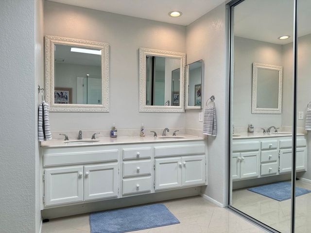 a spacious bathroom with double sink and a mirror