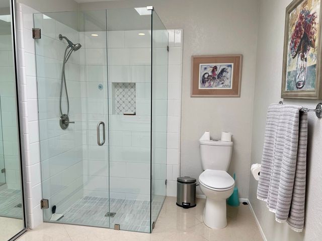 a white toilet sitting next to a bathroom shower