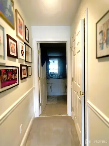 a view of a hallway with wooden floor and a living room