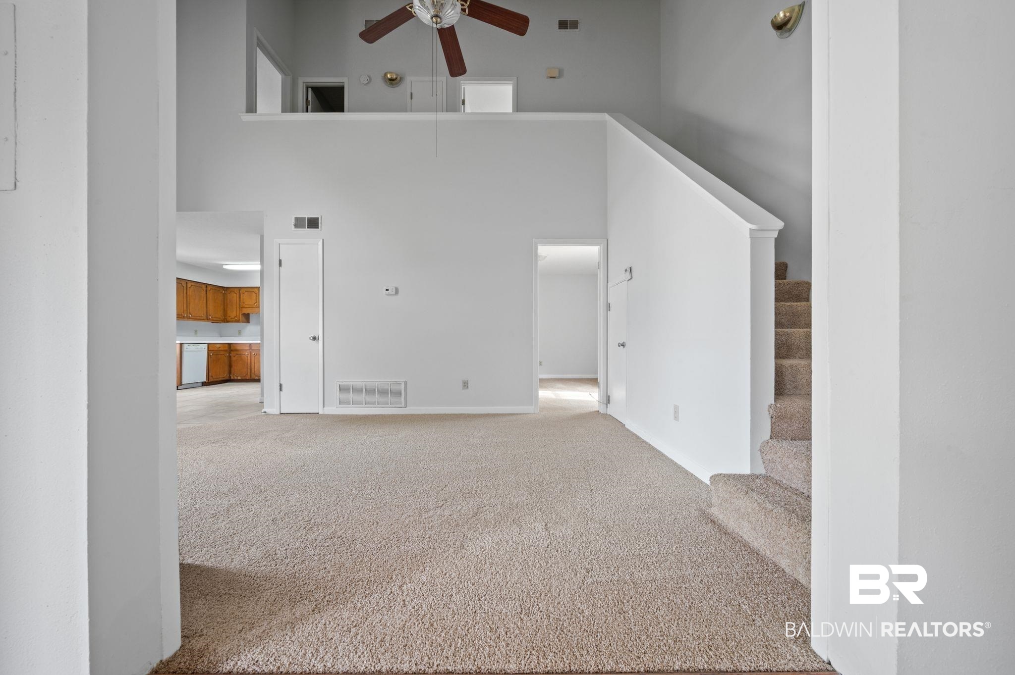 3701 Vista Ridge Drive Mobile, AL 36693 - Photo 24 of 33 Unfurnished living room featuring ceiling fan, a high ceiling, and light colored carpet