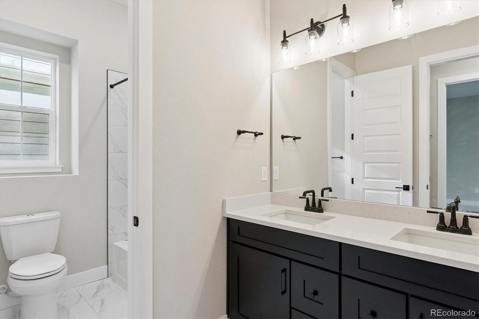 1288 Oleander Street Castle Rock, CO 80109 - Photo 11 of 29 a bathroom with a double vanity sink toilet and shower