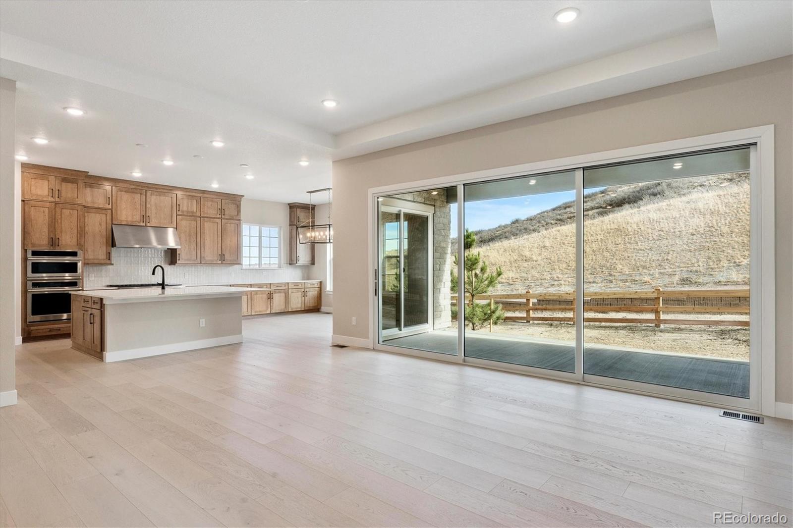 1288 Oleander Street Castle Rock, CO 80109 - Photo 2 of 29 a large white kitchen with large windows and white cabinets