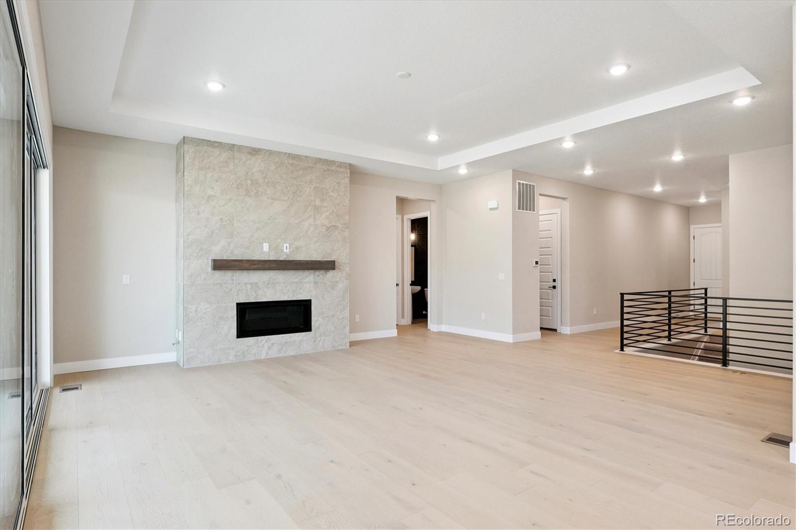 1288 Oleander Street Castle Rock, CO 80109 - Photo 3 of 29 an empty room with kitchen view and a fireplace