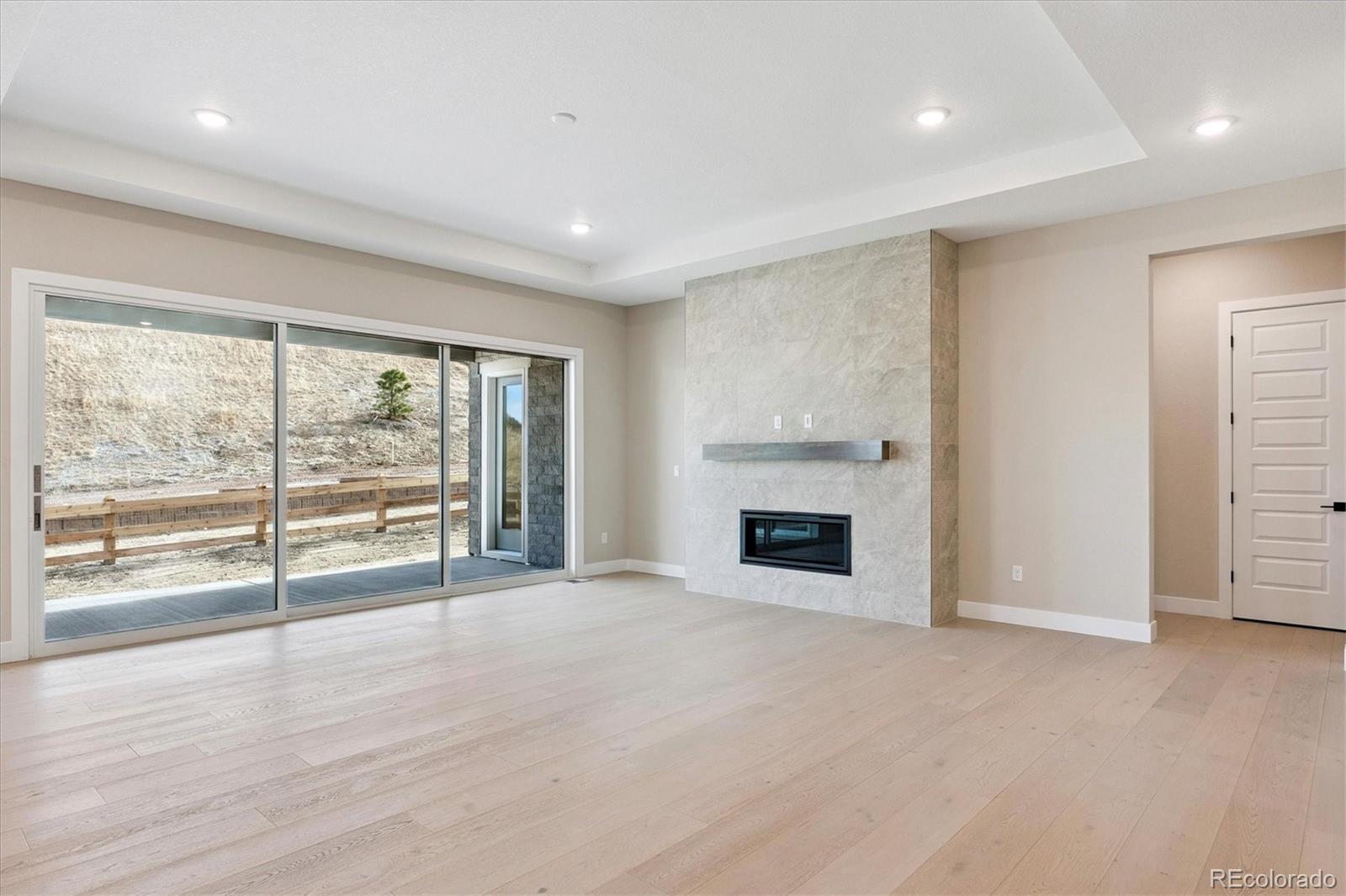 1288 Oleander Street Castle Rock, CO 80109 - Photo 4 of 29 wooden floor fireplace and windows in an empty room