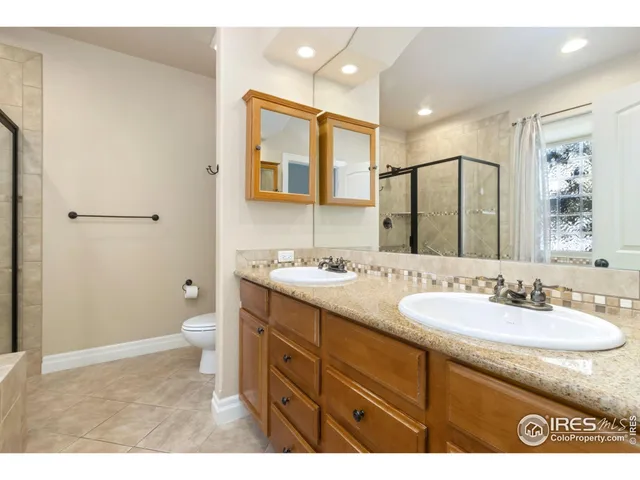 a bathroom with a granite countertop sink mirror and a toilet