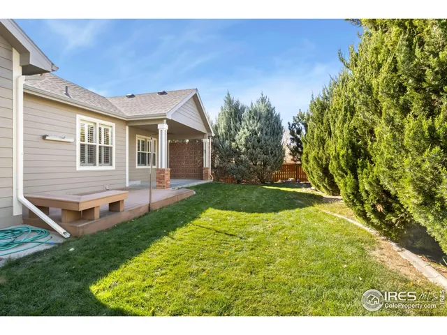 a view of a house with backyard and sitting area