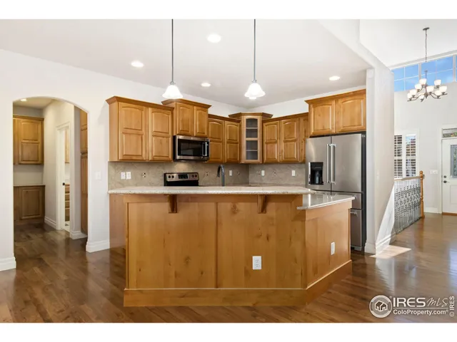 a kitchen with stainless steel appliances granite countertop a refrigerator a sink and a stove
