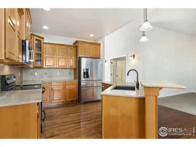 a kitchen with stainless steel appliances granite countertop a sink a stove and refrigerator