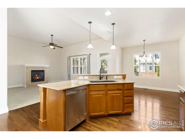 a kitchen with kitchen island granite countertop a sink cabinets and wooden floor