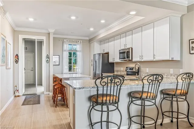 a kitchen with stainless steel appliances granite countertop a stove top oven a refrigerator a sink and a granite counter tops